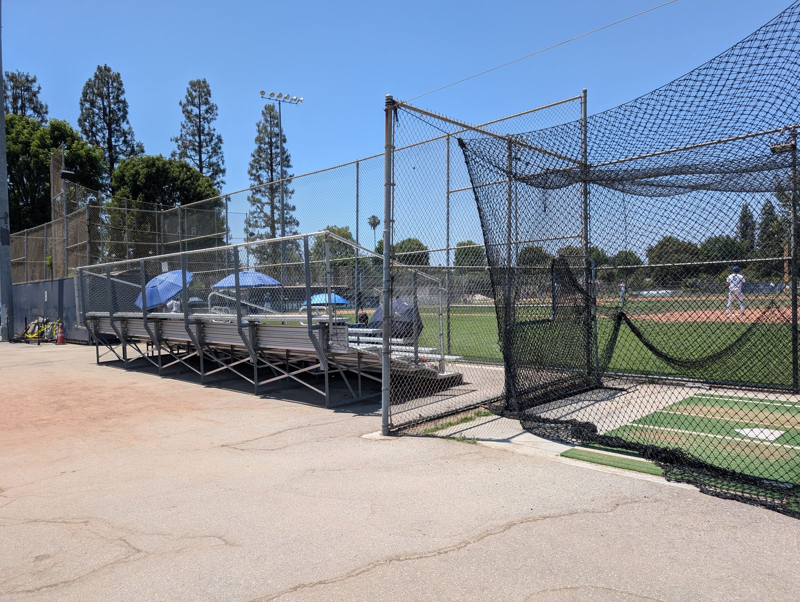 Side bleachers next to the batting cage, field beyond.