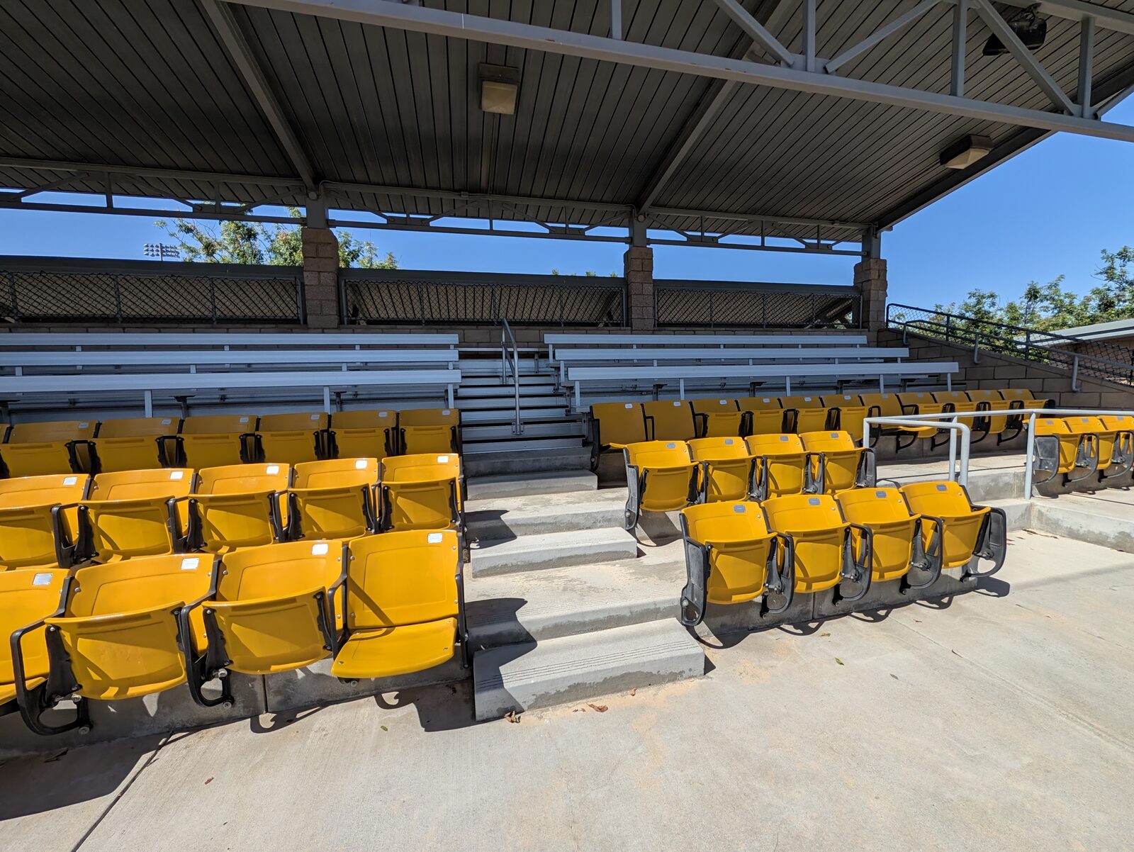 Third-base side at 11:22am. The benches at the back are shaded and the back row of yellow seats has just gone into shade, while the front rows are still in sun.