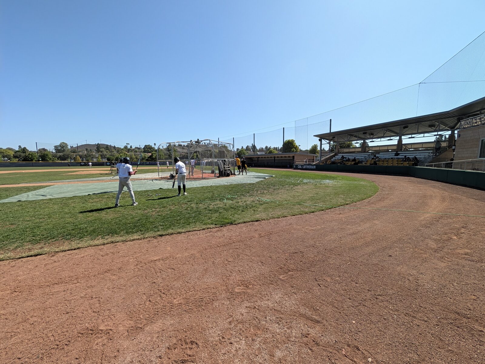 Looking across to home plate and the first-base side from the third-base side: nothing blocks the view, and the covered grandstand opposite is in full shade.