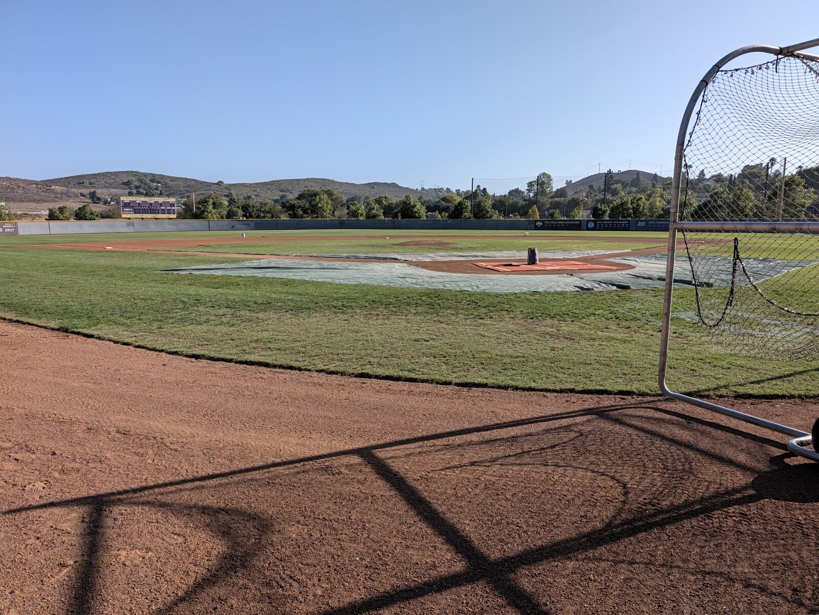 Field level: natural grass, dirt infield, and an outfield wall carrying CLU's championship history.