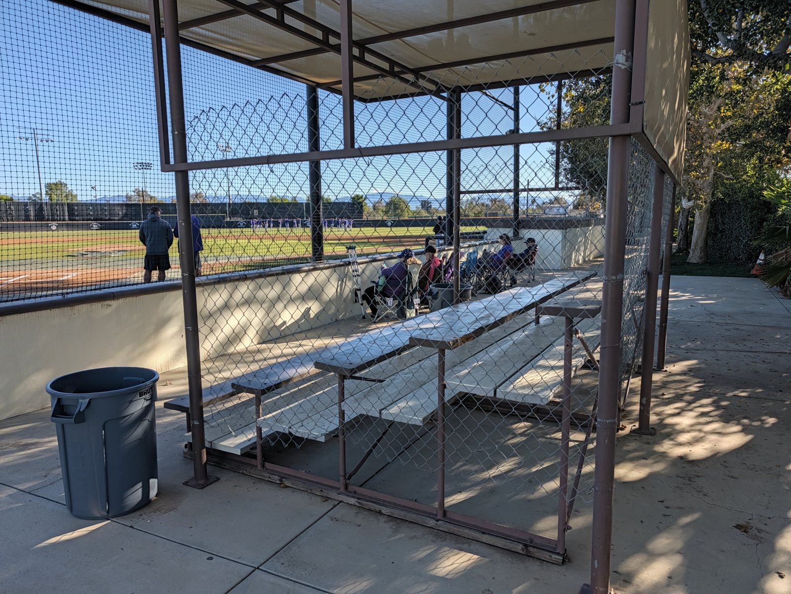 The covered bleacher rows, with chair seating along the wall beyond them.