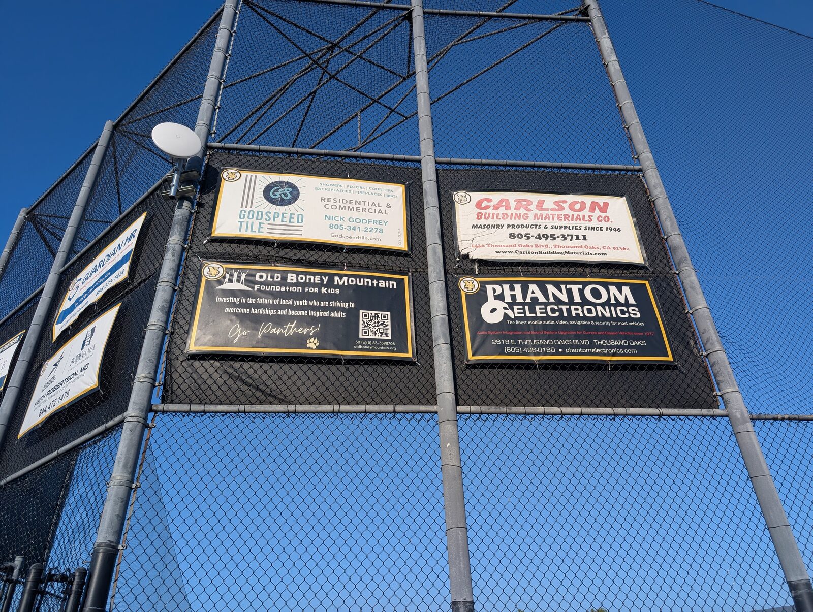 The sponsor banner board on the backstop netting at game time.
