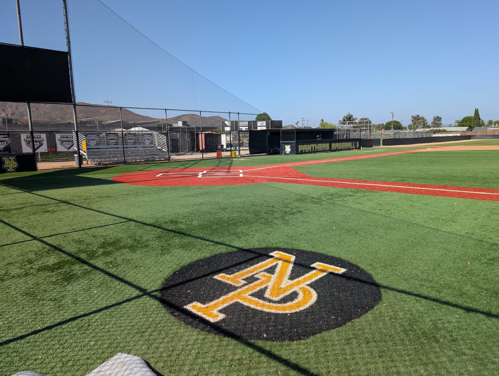 From behind home plate out to center field, the gold NP Panthers logo painted on the turf.