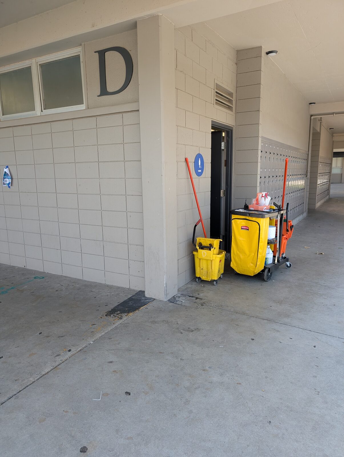 The covered breezeway leading to the restroom doors, with accessible signage.